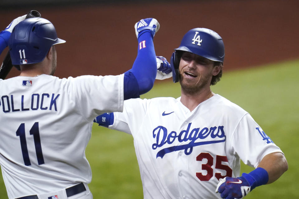 Los Angeles Dodgers' Cody Bellinger (35) is congratulated by A.J. Pollock (11) after his solo home run agains the San Diego Padres during the fourth inning in Game 2 of a baseball National League Division Series Wednesday, Oct. 7, 2020, in Arlington, Texas. (AP Photo/Sue Ogrocki)