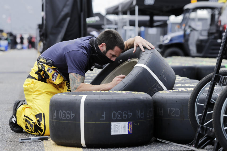 Tires are checked by a crew member for driver Erik Jones before the start of the NASCAR Cup Series auto race Sunday, May 17, 2020, in Darlington, S.C. (AP Photo/Brynn Anderson)