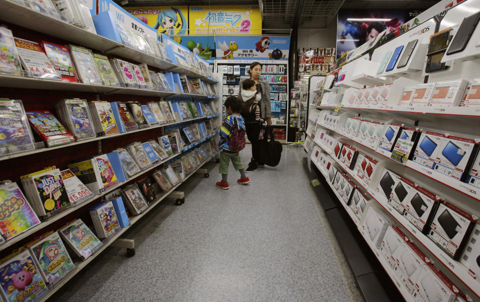 In this photo taken Sunday, Dec. 15, 2013, shoppers walk through the sales floor of Nintendo 3DS video game software at an electronics store in Tokyo. Nintendo Co. says its profit for the first nine months of the fiscal year fell 30 percent because of languishing sales of its Wii U home consoles and game software. The Japanese maker of Super Mario video games reported Wednesday, Jan. 29, 2014, a 10.2 billion yen ($99 million) profit from April to December, down from 14.55 billion yen a year earlier. It did not break down quarterly numbers. (AP Photo/Shizuo Kambayashi)