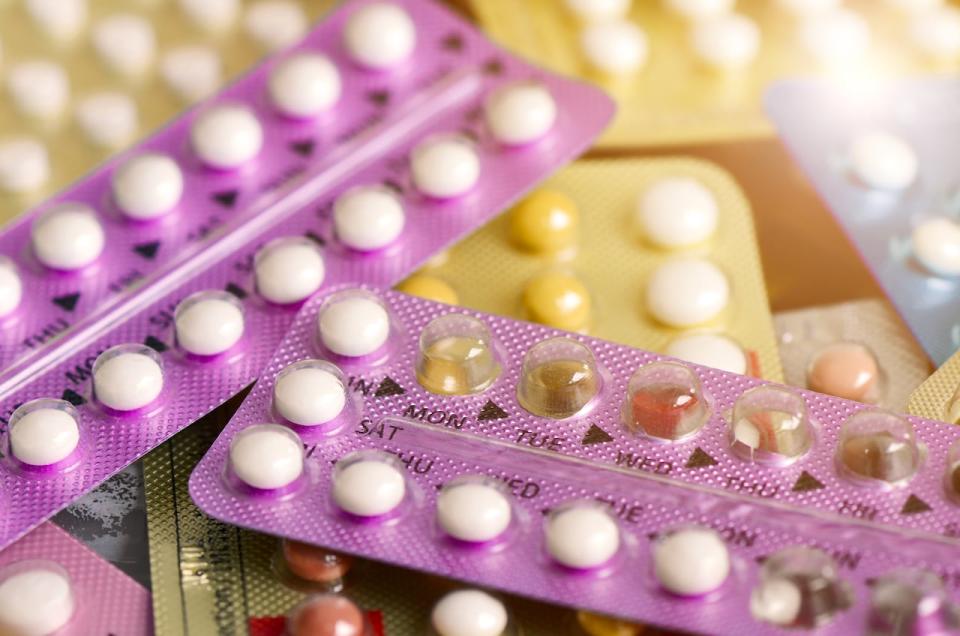 Oral contraceptive pill on pharmacy counter with colorful pills strips background. Photo ID: 660070825