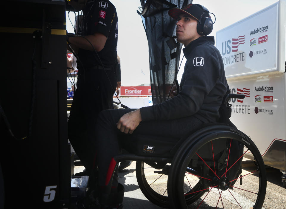 FILE - In this March 8, 2019, file photo Robert Wickens sits in the pit area at the IndyCar Grand Prix of St. Petersburg auto race in St. Petersburg, Fla. Nearly a year after his devastating injury in an IndyCar race, Wickens will indeed get to drive a car again at a race track. He will lead the parade lap Sunday before the Toronto IndyCar race in an Acura NSX equipped with hand controls. (Dirk Shadd/Tampa Bay Times via AP, File)