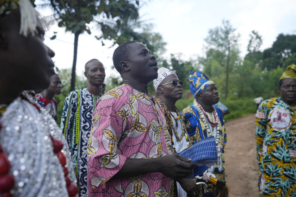 A voodoo priest calls on the spirit outside the Oro sacred forest in Adjarra, Benin, on Wednesday, Oct. 4, 2023. As the government grapples with preserving the forests while developing the country, Voodoo worshippers worry the loss of its spaces could have far reaching effects. (AP Photo/Sunday Alamba)