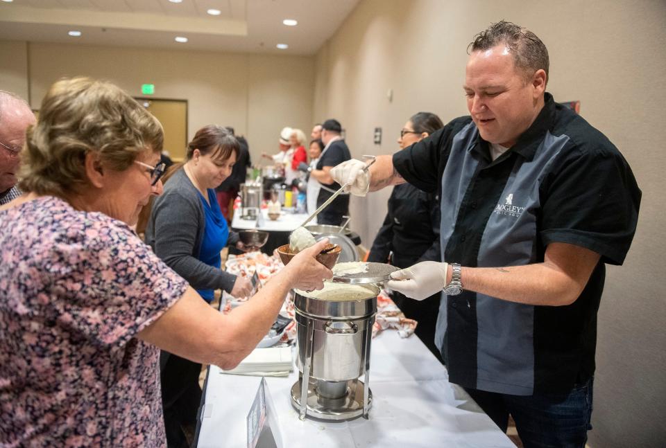 Mike Midgley of Midgley's Public House serves up his clam chowder to Lori Podesta at the Art Expressions of San Joaquin's Souper Supper fundraising event at the Hilton Hotel in Stockton on Friday, Feb. 17, 2023. The event, which featured soups made by community and restaurant chefs, is a fundraiser for the Art Expressions' free arts programs and summer youth classes the group holds in conjunction with the libraries and the Children's Museum. This was the first Souper Supper since 2020 due to the COVID-19 pandemic.
