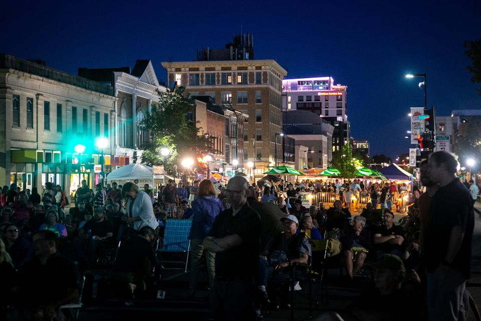 Concert-goers listen to musicians perform during Iowa Arts Festival, Friday, June 3, 2022, in Iowa City, Iowa.