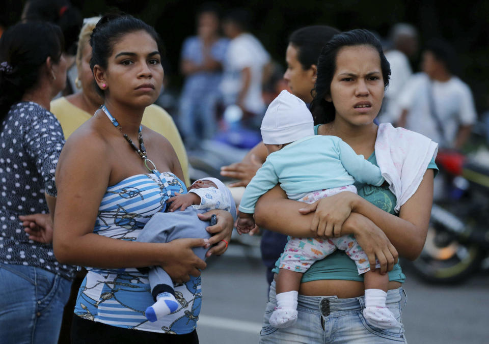 Women with their babies line up to receive medial aids during a distribution of food distributed by the Nicolas Maduro's government near the international bridge of Tienditas on the outskirts of Urena, Venezuela, Monday, Feb. 11, 2019. Nearly three weeks after the Trump administration backed an all-out effort to force out President Nicolas Maduro, the embattled socialist leader is holding strong and defying predictions of an imminent demise. (AP Photo/Fernando Llano)