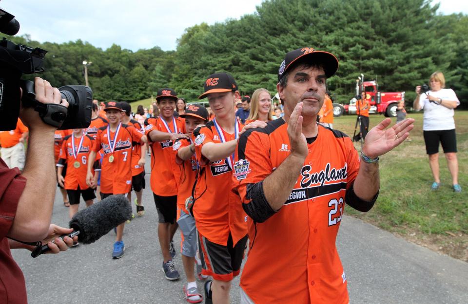 Manager Dave Belisle leads his Cumberland American team onto the stage at Diamond Hill Park for a welcome-home ceremony in August 2014 after they had returned from Little League World Series in Williamsport, Pa.