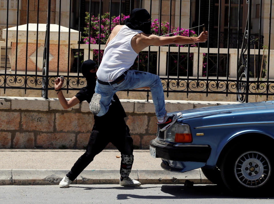 Palestinian protesters hurl stones towards Israeli troops in the West Bank