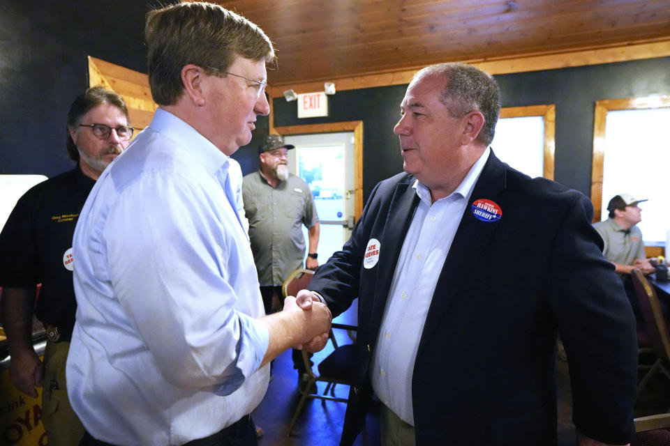 Mississippi Republican Gov. Tate Reeves, who is seeking reelection is greeted by Lowndes County Sheriff Eddie Hawkins, right, at a campaign breakfast in Columbus, Miss., Monday, Oct. 23, 2023. Reeves faces Democratic nominee Brandon Presley, current Mississippi Public Service Commissioner for the Northern District, on Nov. 7. (AP Photo/Rogelio V. Solis)