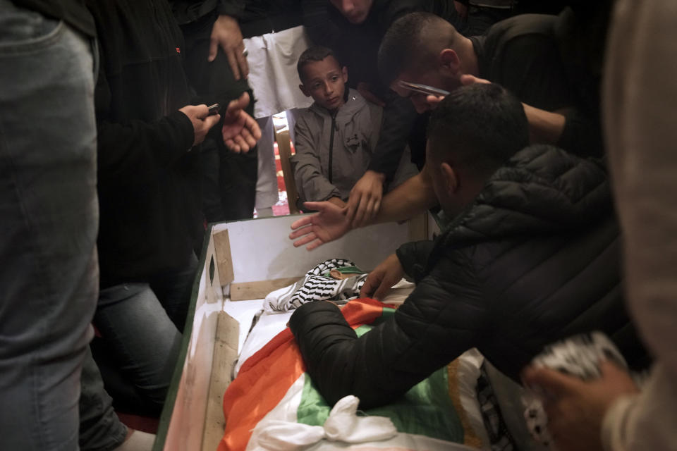 Mourners gather around the body of Palestinian, Waleed Shareef, 21, during his funeral at the Al Aqsa Mosque compound in Jerusalem's Old City, Monday, May 16, 2022. Shareef died Saturday from a head wound sustained last month after Israeli police fired rubber bullets at stone-throwing Palestinian demonstrators during violence at the Al Aqsa Mosque compound, in Jerusalem's Old City. (AP Photo/Mahmoud Illean)