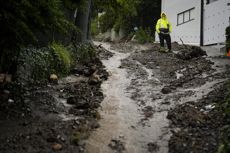 A first responder stands atop a hill in the aftermath of a mudslide, Monday, Feb. 5, 2024, in the Beverly Crest area of Los Angeles. (AP Photo/Marcio Jose Sanchez)
