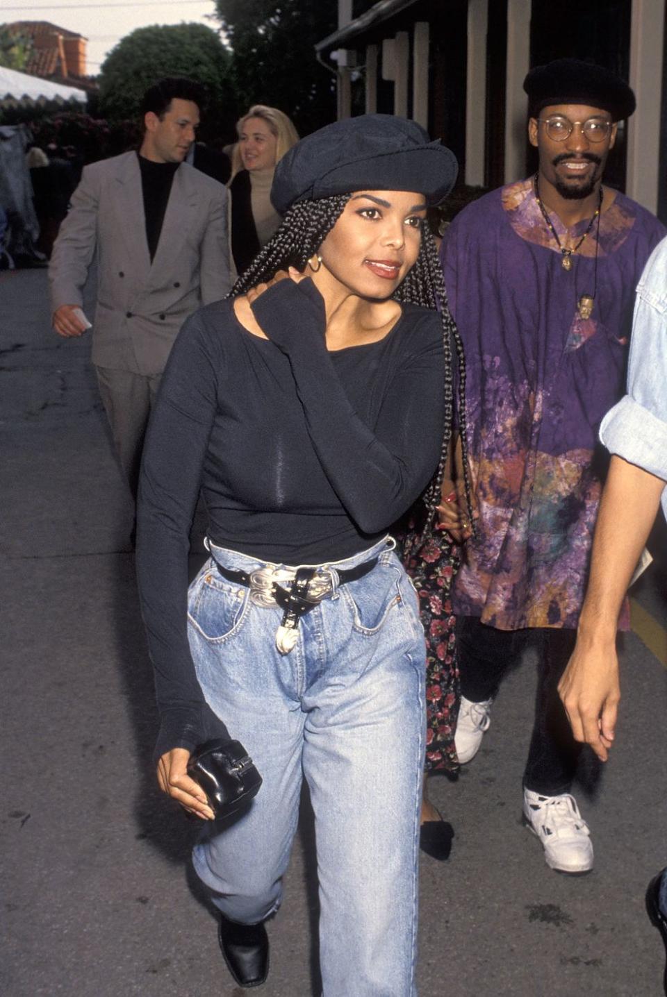 <p> This laidback but classic '90s look by the singer and actor can easily be recreated present day. The Poetic Justice star tucked a long-sleeved boatneck tee into a belted pair of mom jeans and wore a newsboy cap over her long box braids. </p>