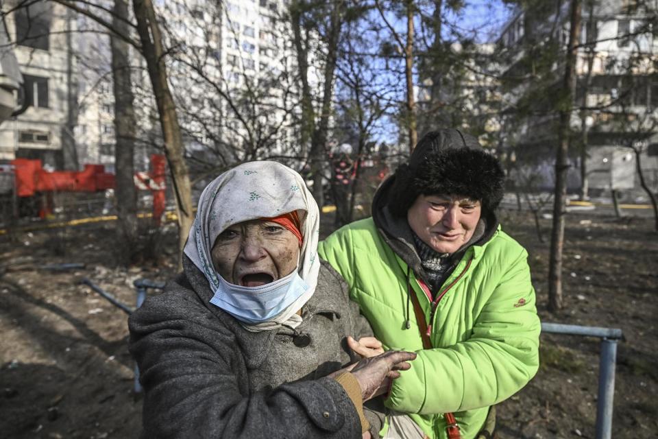 Eine Frau wird aus einem brennenden Wohnhaus in Kiew evakuiert. 15. März 2022