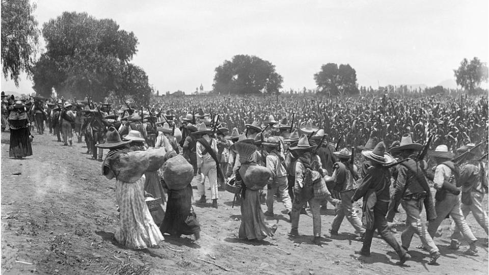 Hombres y mujeres marchan durante la revolución mexicana.