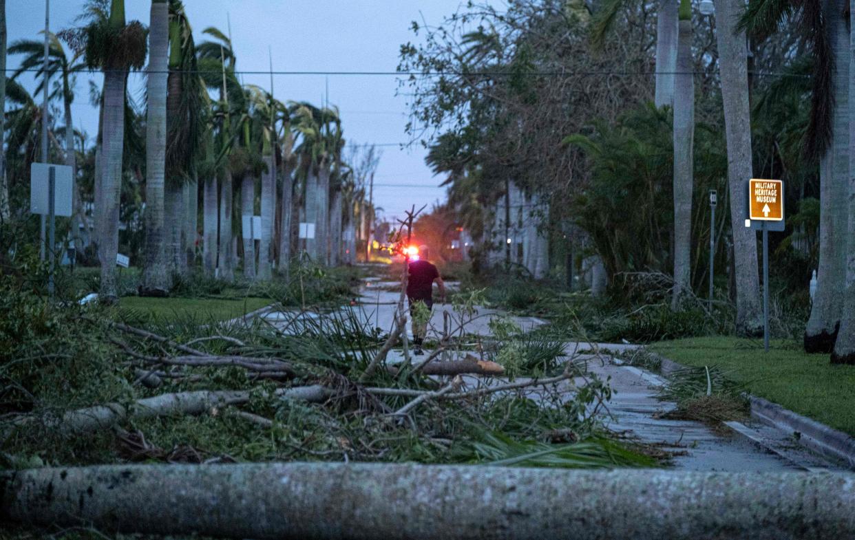 A man walks through debris on a street in the aftermath of Hurricane Ian in Punta Gorda, Fla., on Sept. 29, 2022.