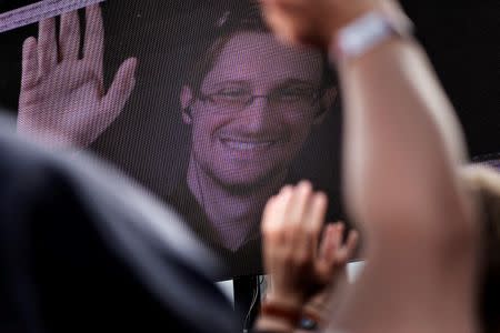 Revellers react as American whistleblower Edward Snowden is seen on a screen during the Roskilde Festival in Roskilde, Denmark, June 28 2016. Scanpix Denmark/Mathias Loevgreen Bojesen /via REUTERS