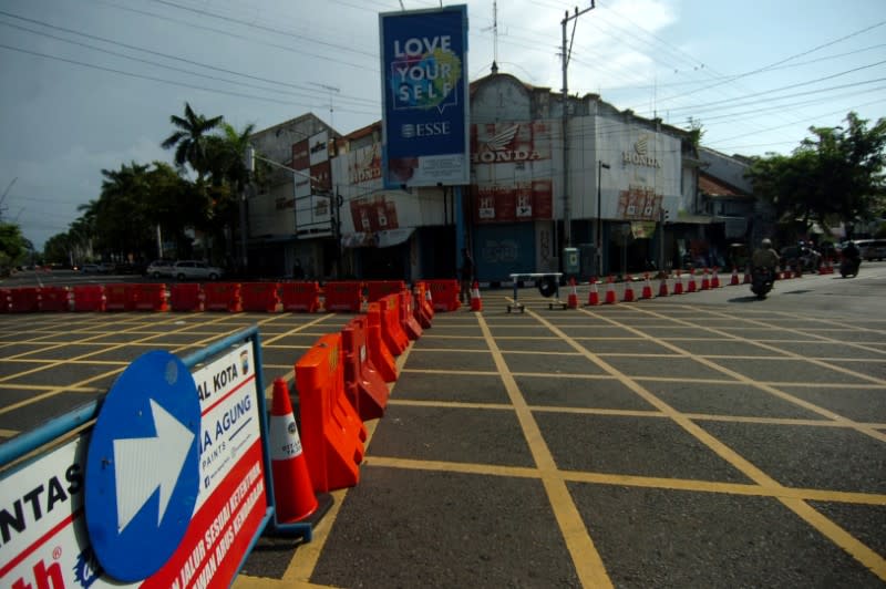 The vehicles drive by near road barriers during the lockdown amid the coronavirus disease (COVID-19) outbreak