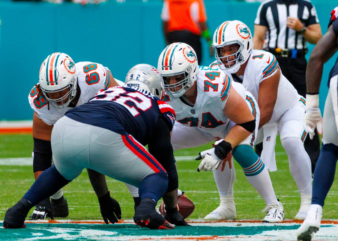 Miami Dolphins offensive tackles Robert Hunt (68) and Liam Eichenberg (74) protect teammate Dolphins quarterback Tua Tagovailoa (1) from New England Patriots defensive tackle Davon Godchaux (92) during second quarter of an NFL football game at Hard Rock Stadium on Sunday, Oct. 29, 2023 in Miami Gardens, Fl. David Santiago/dsantiago@miamiherald.com