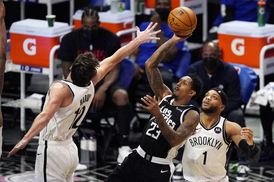 Los Angeles Clippers guard Lou Williams, center, shoots as Brooklyn Nets forward Joe Harris, left, and guard Bruce Brown defend during the first half of an NBA basketball game Sunday, Feb. 21, 2021, in Los Angeles.