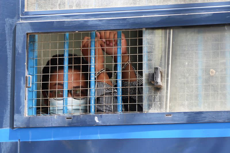 Member of the All Burma Federation of Students Union, looks out from a prison van window after a trial in Mandalay