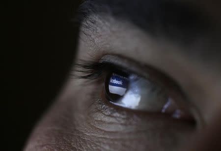 A picture illustration shows a man looking at the Facebook website on a tablet in Sofia June 27, 2012. REUTERS/Stoyan Nenov