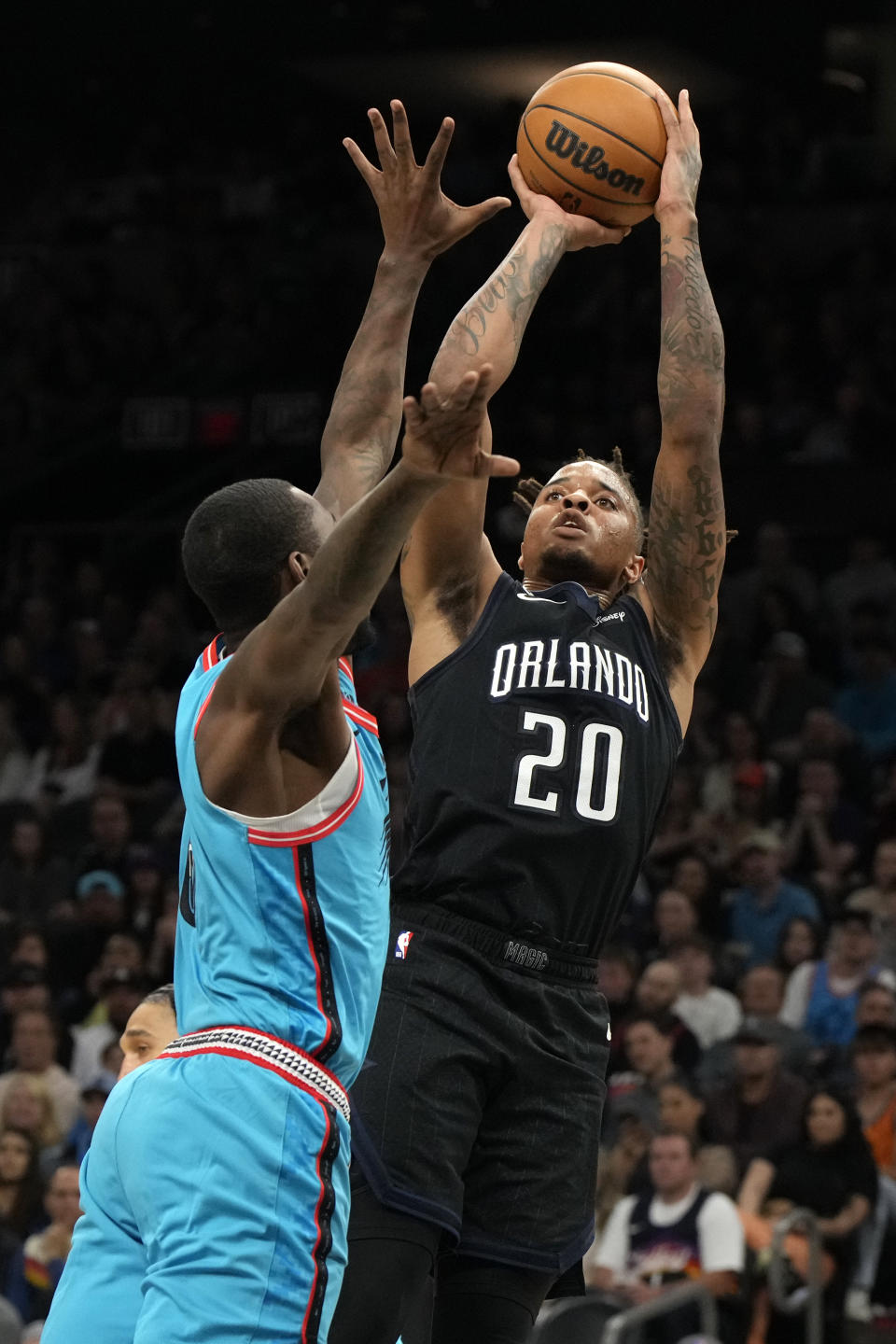 Orlando Magic guard Markelle Fultz (20) shoots over Phoenix Suns guard Terrence Ross during the first half of an NBA basketball game, Thursday, March 16, 2023, in Phoenix. (AP Photo/Rick Scuteri)