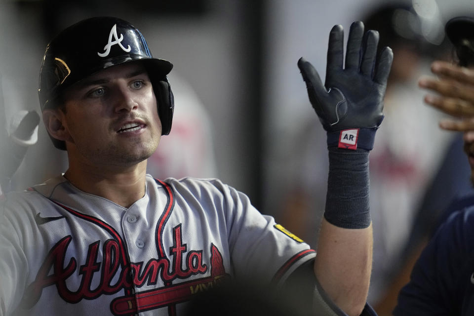 Atlanta Braves' Austin Riley gets high-fives in the dugout after his home run against the Cleveland Guardians during the seventh inning of a baseball game Wednesday, July 5, 2023, in Cleveland. (AP Photo/Sue Ogrocki)