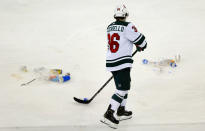 Minnesota Wild's Mats Zuccarello (36) helps collect debris thrown on the ice by fans during the third period of an NHL hockey game against the New York Rangers, Friday, Jan. 28, 2022, in New York. The Rangers thought they had tied the game with two seconds left, but it was ruled no goal by the referees. (AP Photo/John Munson)