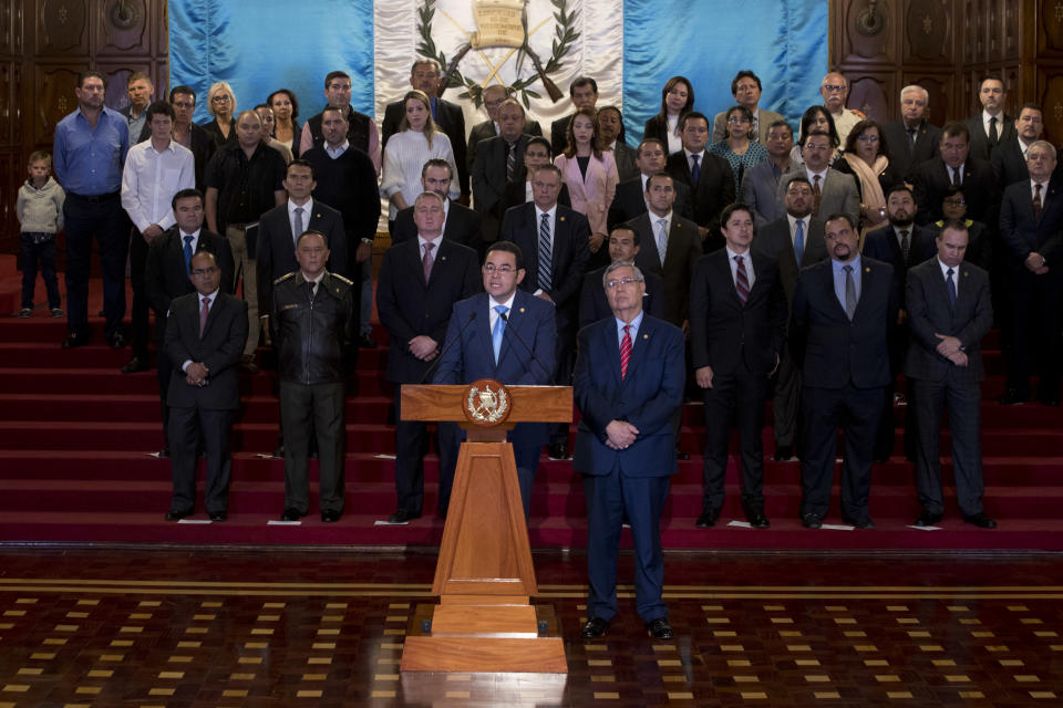 Guatemala's President Jimmy Morales, center, gives a statement, at the National Palace in Guatemala City, Monday, Jan. 7, 2019. Guatemala announced that it is going to withdraw from UN-sponsored anti-corruption commission. (AP Photo/Moises Castillo)