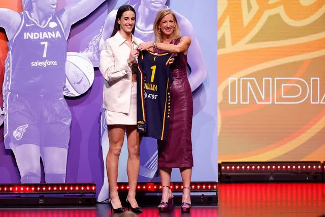 <p>Sarah Stier/Getty</p> Caitlin Clark poses with WNBA Commissioner Cathy Engelbert