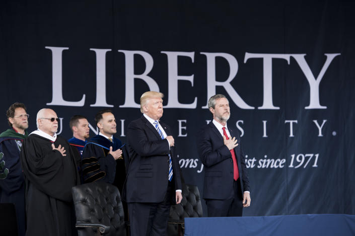 President Donald Trump and Jerry Falwell Jr. (right) participate in the Pledge of Allegiance during Liberty University's commencement ceremony on May 13, 2017, in Lynchburg, Virginia. (Photo: BRENDAN SMIALOWSKI via Getty Images)