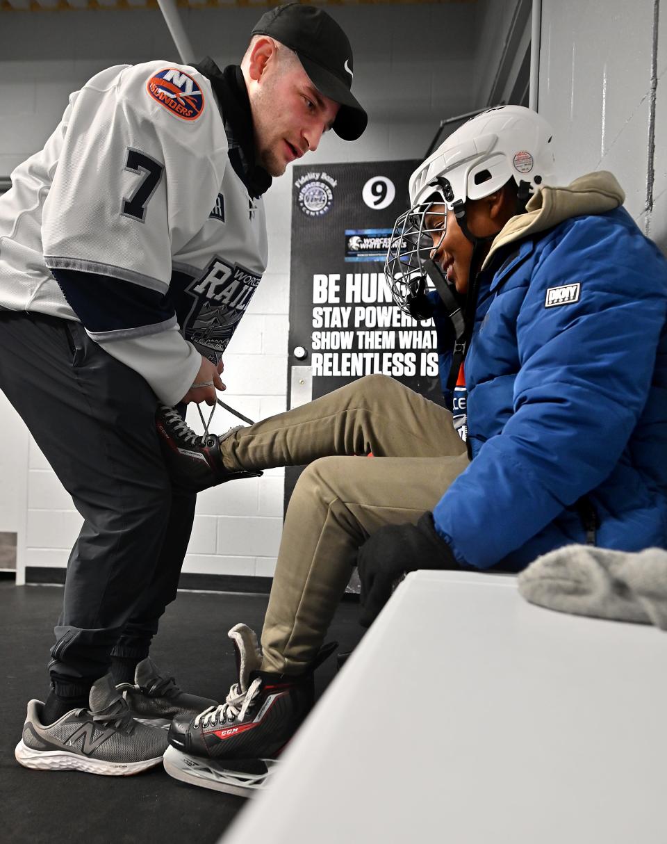 WORCESTER - Worcester Railers player Nick Pennucci ties the skates of Thorndyke Elementary School fourth grader Montana Barnes during the Worcester Railers "Skate To Success" event on Tuesday at Worcester Ice Center.