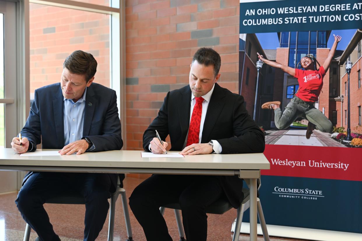 Columbus State Community College President David Harrison and Ohio Wesleyan University President Matt vandenBerg sign partnership agreements Thursday at Columbus State's Delaware campus. The two schools announced three new partnerships — including a first-of-its-kind partnership — which they say is one of the nation's most expansive collaborations between a national liberal arts university and a community college.