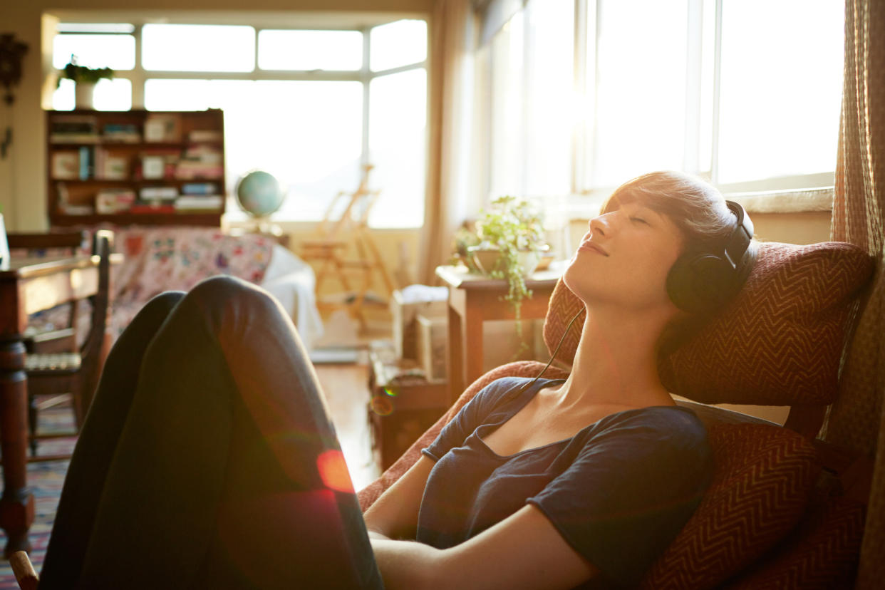Young woman relaxing with headphones at home - Credit: Klaus Vedfelt/Getty Images