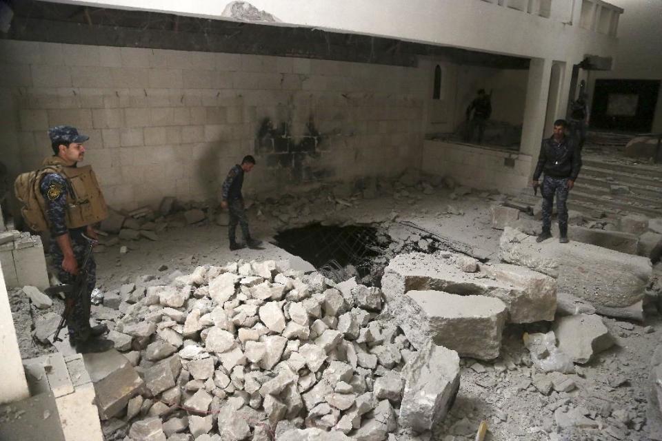 Iraqi federal policemen inspect the inside of Mosul's heavily damaged museum. Most of the artifacts inside the building appeared to be completely destroyed. The basement level that was the museum's library had been burned. The floors were covered in the ashes of ancient manuscripts, in western Mosul, Iraq, Wednesday, March 8, 2017. (AP Photo/Khalid Mohammed)