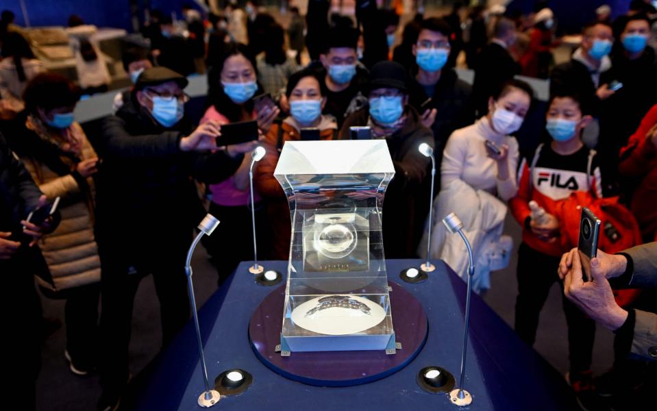 People look at lunar soil collected from China's Chang'e-5 moon mission display during an exhibition - WANG ZHAO /AFP 