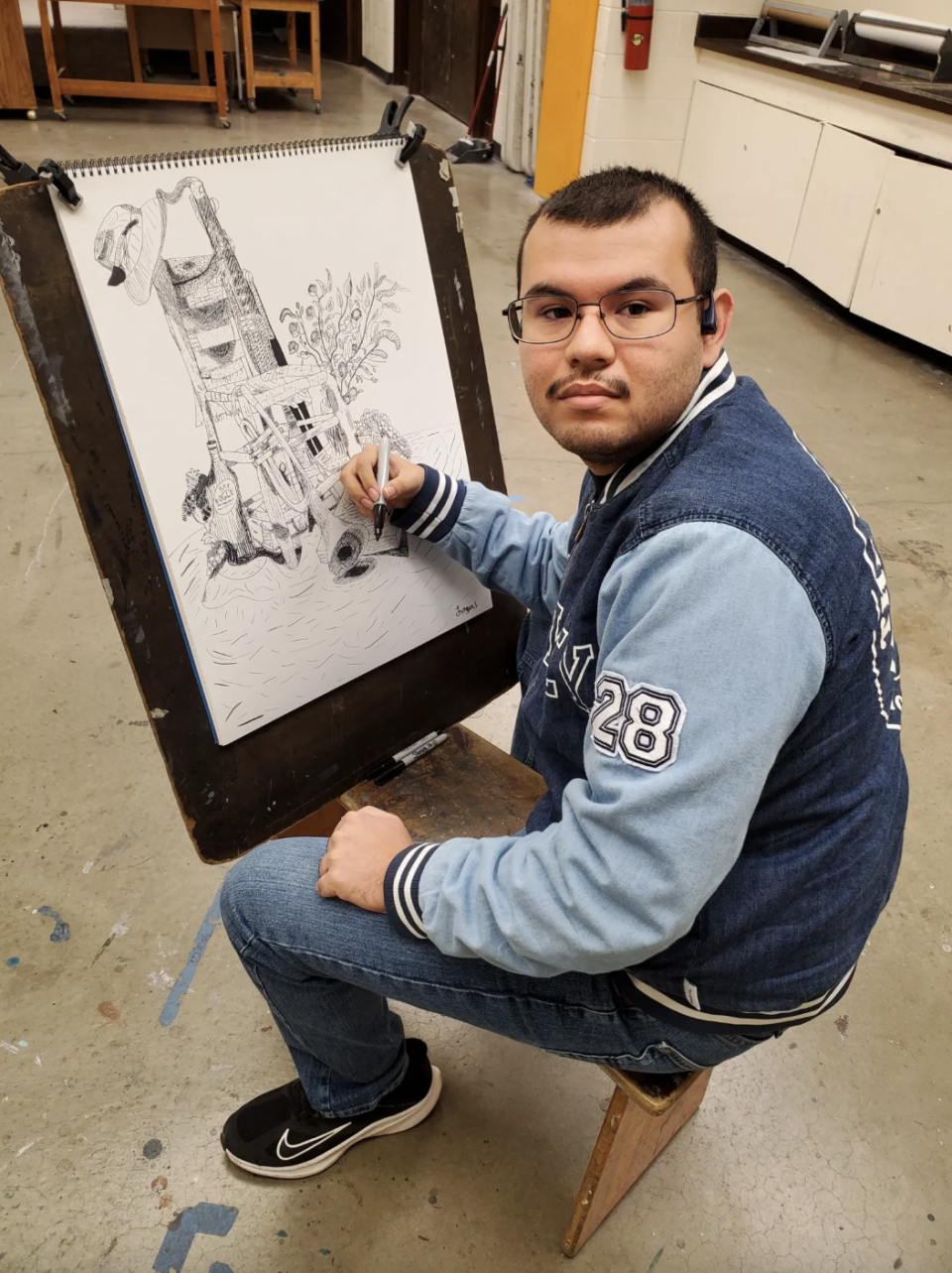 Jurgen Linder, a graduate of Project HIGHER, works on one of the illustrations that he prepared for an art course that is part of his graphic arts degree plan. (Daniel Perez/El Paso Matters)