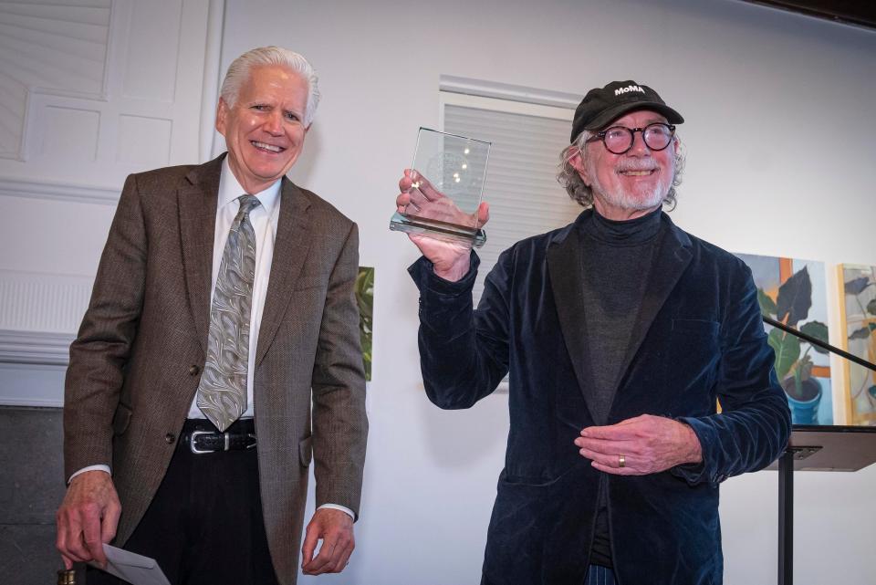 Vermont filmmaker Jay Craven, right, displays the Herb Lockwood Prize he was awarded in Burlington on Oct. 21, 2023, as Lockwood's brother, Todd R. Lockwood, looks on.