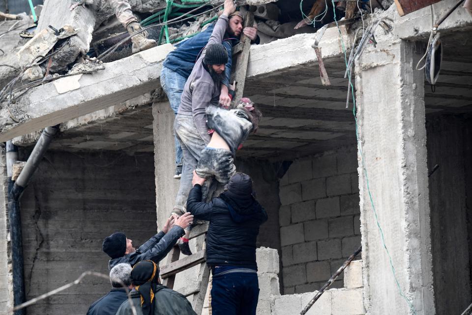 <p>Los sobrevivientes de un edificio colapsado rescatan a una niña de los escombros en la localidad de Jandaris. (Photo by Rami al SAYED / AFP) (Photo by RAMI AL SAYED/AFP via Getty Images)</p> 