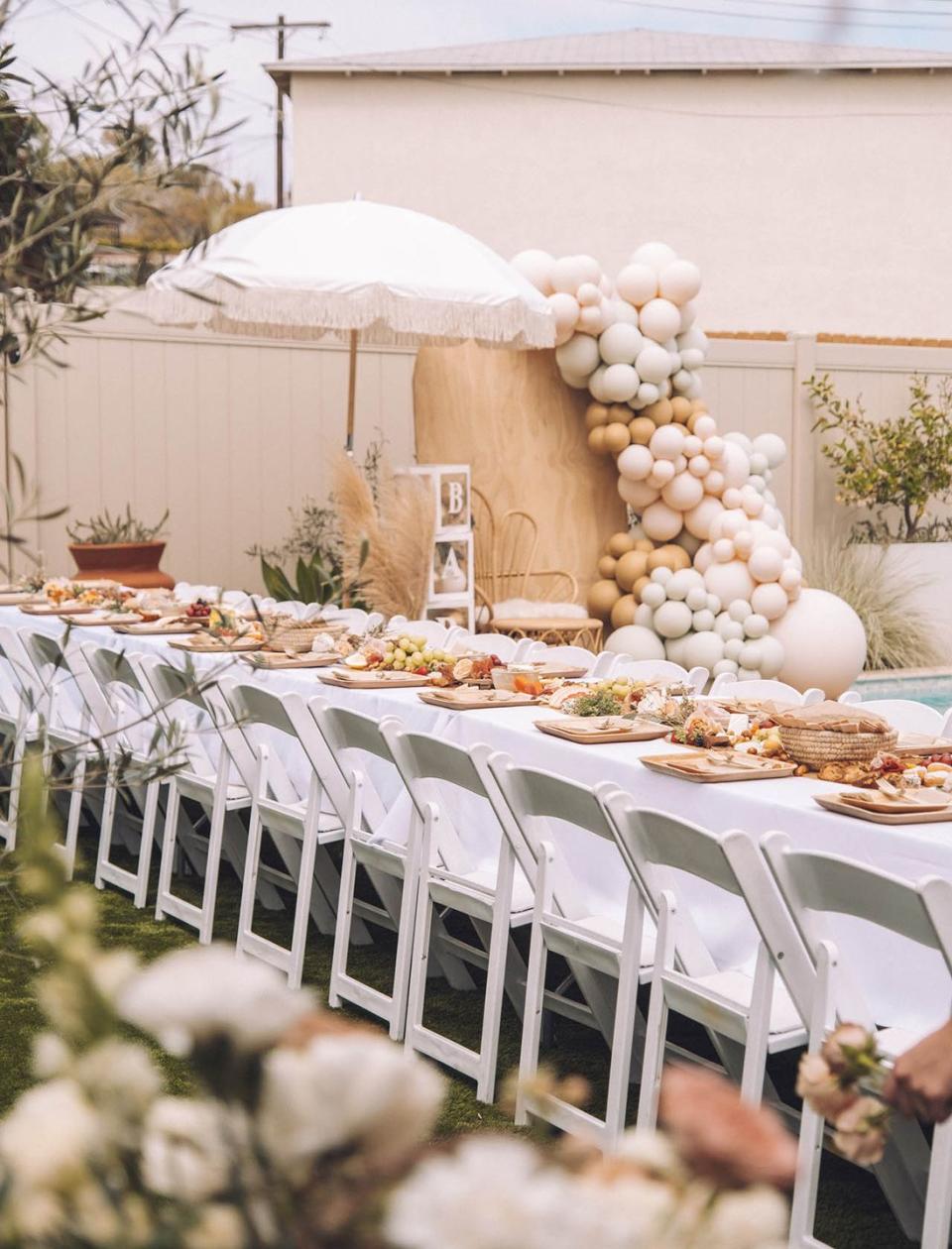 a netural baby shower uses a long picnic table, a great baby shower idea