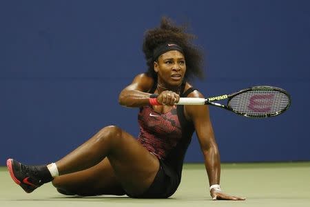 Serena Williams of the U.S. follows the flight of the ball as she falls on a return shot to her sister and compatriot Venus Williams during their quarterfinals match at the U.S. Open Championships tennis tournament in New York, September 8, 2015. REUTERS/Shannon Stapleton