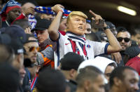 A PSG fan wears a mask depicting US President Donald Trump in the stands ahead of the Champions League Group C soccer match between Liverpool and Paris-Saint-Germain at Anfield stadium in Liverpool, England, Tuesday, Sept. 18, 2018. (AP Photo/Dave Thompson)