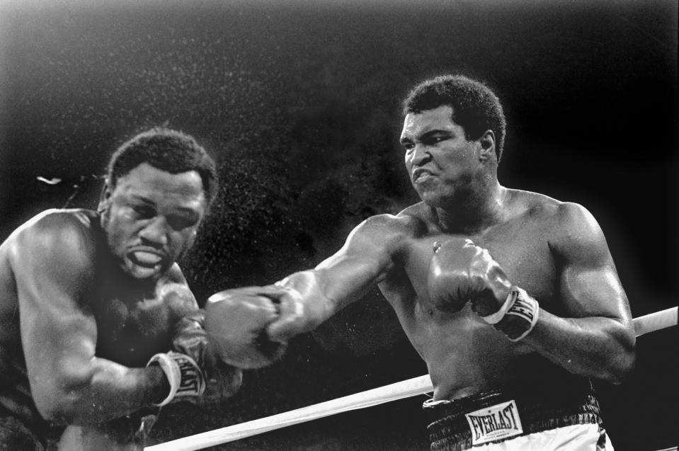 Sweat flies from the head of Joe Frazier as heavyweight champion Muhammad Ali connects with a right in the ninth round of their title fight in Manila, Philippines, in this Oct. 1, 1975 file photo. (AP Photo/Mitsunori Chigita)