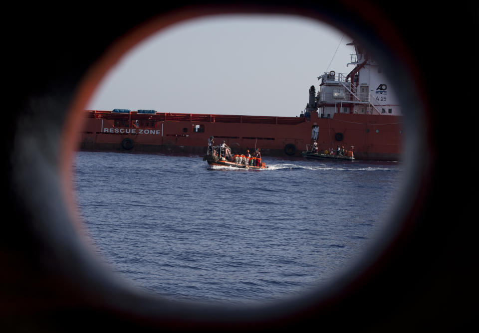 FILE - In this Wednesday, Aug. 30, 2017 file photo, rescuers transfer migrants rescued by an oil rig supply ship to the Aquarius vessel of SOS Mediterranee and MSF (Doctors Without Borders) NGOs, in the Mediterranean Sea, north of Libyan coast. Migrants trying to reach Europe face routine rape and sexual torture throughout their journey _ and especially in Libya _ with men facing abuse nearly as routinely as women, according to a study based on dozens of interviews with aid workers and migrants. (AP Photo/Darko Bandic, File)