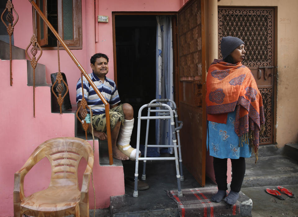 In this Feb. 20, 2014 photo, Indian man Ashok Yadav sits on a staircase outside his house, with his wife Laxmi Yadav beside him at a leper colony in New Delhi, India. The stigma of leprosy endures in India, even though the country has made great strides against the disease, which is neither highly contagious nor fatal. Now the number of new annual cases has risen slightly after years of steady decline, and medical experts say the enormous fear surrounding leprosy is hindering efforts to finally eliminate it.(AP Photo/Manish Swarup)