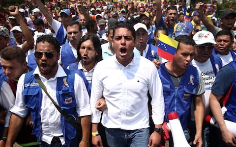 Venezuela's opposition lawmaker Jose Manuel Olivares and supporters march toward the Simon Bolivars bridge on the outskirts of Cucuta - Credit: Reuters
