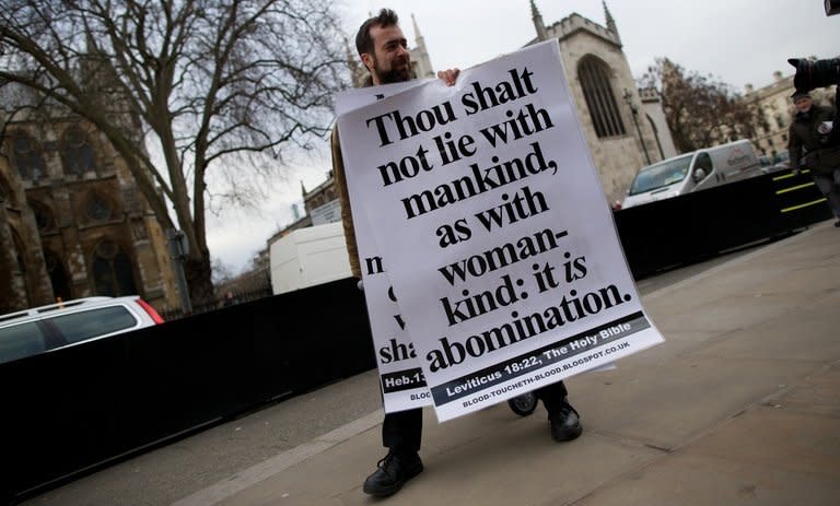 A man holds a placard bearing a passage from the Bible during a protest against legislation allowing gay marriage in London on February 5, 2013