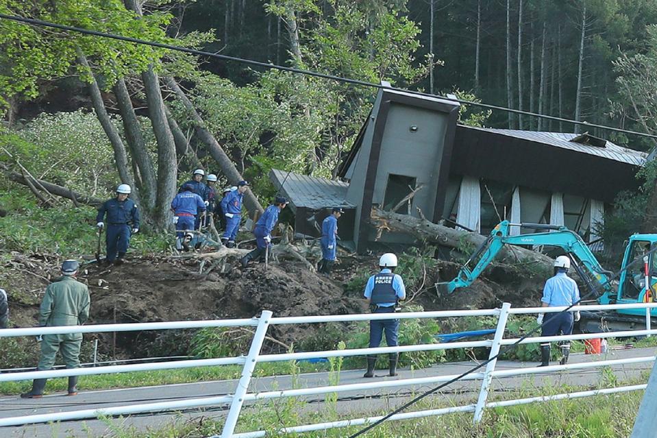 <p>Police and rescue workers search for survivors at a house that was damaged by a landslide in Atsuma town in Hokkaido prefecture Tuesday.</p>