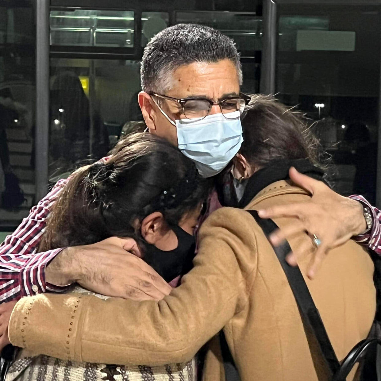 Ahmad Sarmast hugs Zohra and Farida, both aged 13, as they arrived in Doha, Qatar. (Omar Nashat)