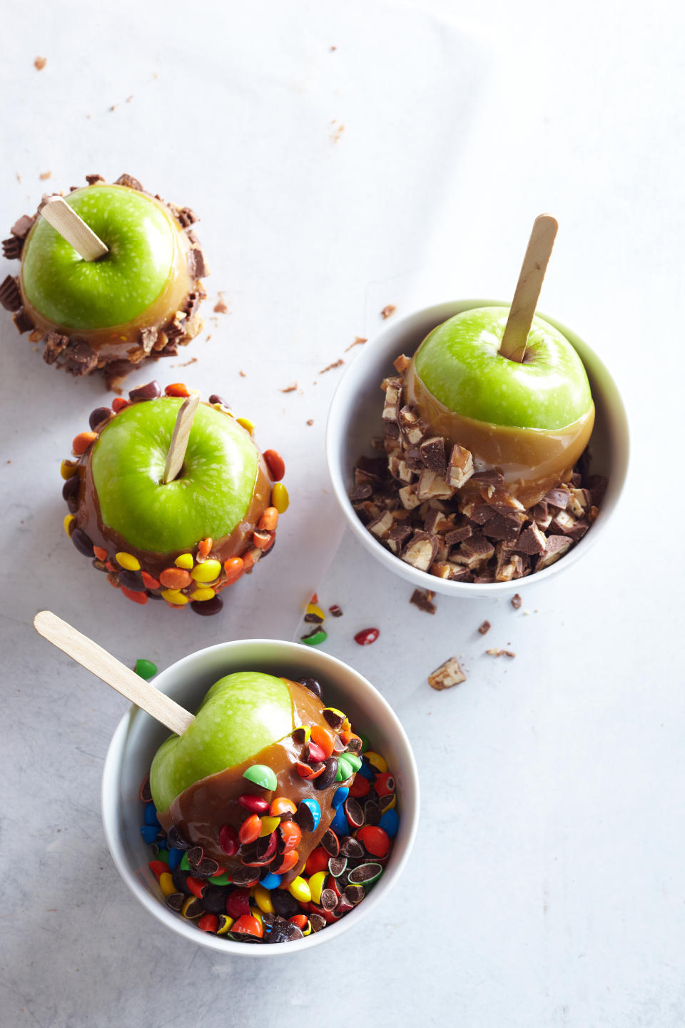 This photo supplied by Better Homes & Gardens shows a selection of caramel apples. The classic caramel apple makes a fun party activity, says Southern Living’s senior lifestyle producer Ivy Odom. Set up a bar with full apples or chunky slices, a crockpot of melted caramel, and toppings to sprinkle or dip. (Blaine Moats/Better Homes & Gardens via AP)