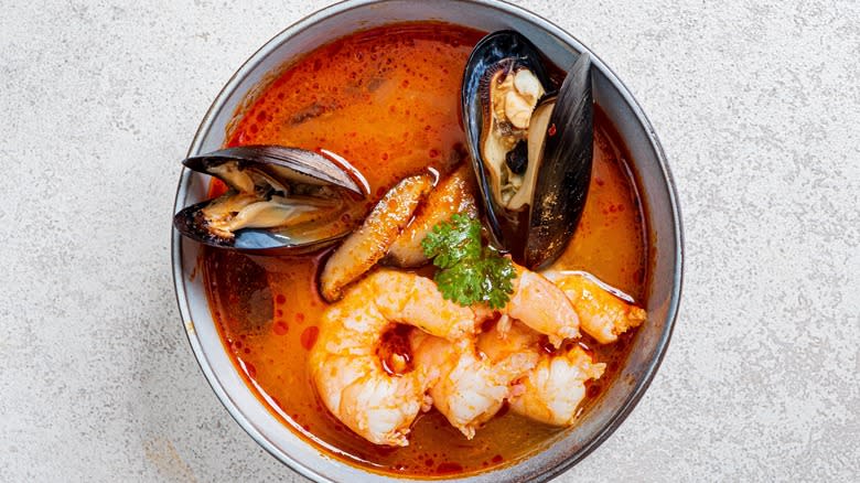 Red soup topped with shellfish